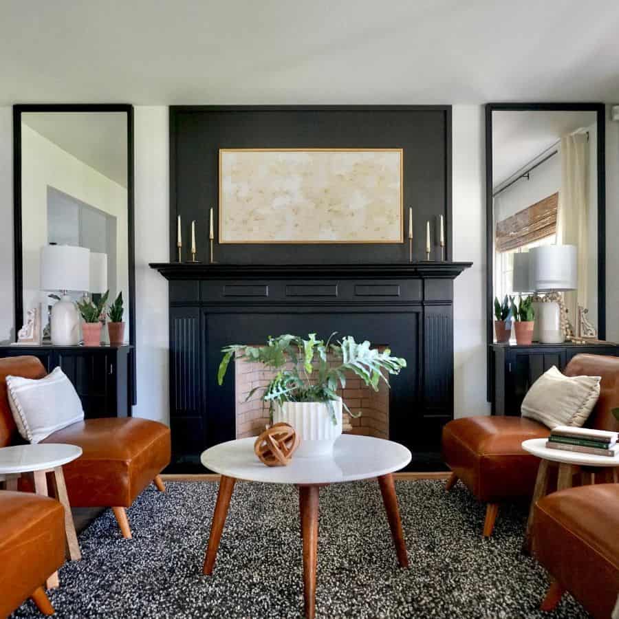 elegant living room tan leather lounge chairs black fireplace candles small white marble top table floor rug