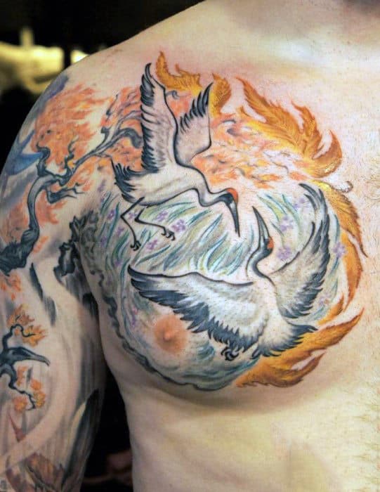 Leaves Blowing In The Wind With Crane Birds Flying Mens Upper Chest Tattoo