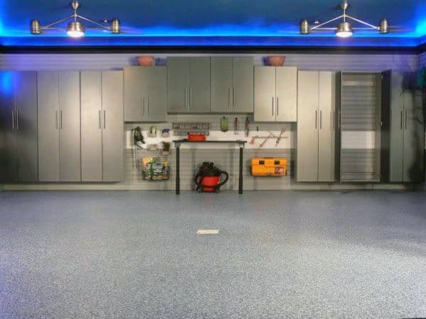 Modern garage with blue LED lighting, sleek cabinets, and organized workspace.