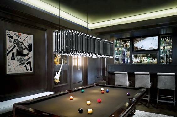 Contemporary billiard room with black felt table, LED lighting, and a built-in bar area.