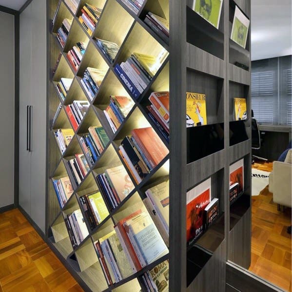 Modern bookshelf with diagonal shelves, books glowing from behind in a stylish room