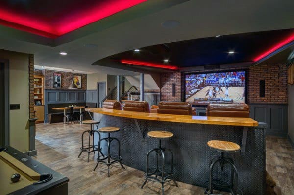 Basement with red LED ceiling lighting, bar seating, pool table, and a large screen for sports.