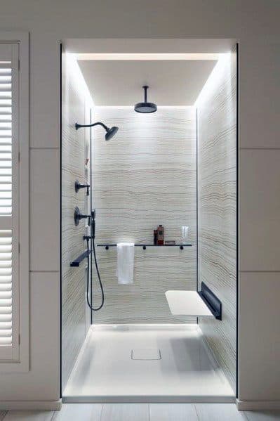 Modern shower with sleek LED lighting along the ceiling and walls, complemented by elegant textured tiles for a luxurious feel