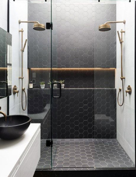 Chic shower with modern hexagonal tiles, dual showerheads, and recessed LED lighting in the niche shelf for a stylish touch