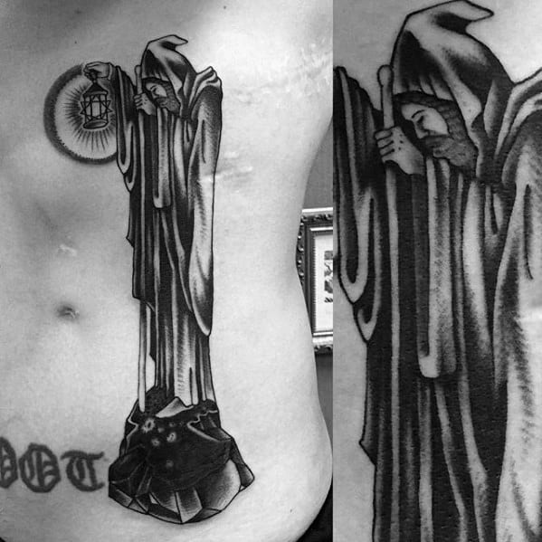 Stomach and side torso tattoo of the hooded hermit holding a glowing lantern, inspired by Led Zeppelin’s 'Stairway to Heaven' artwork.