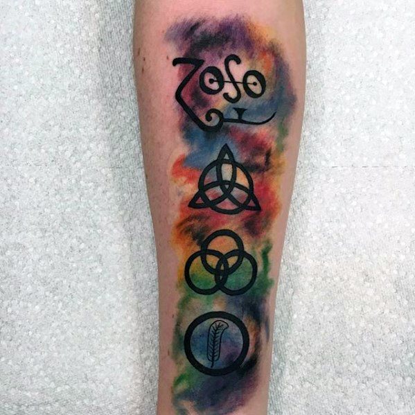 Forearm tattoo of the four Led Zeppelin symbols—Zoso, triquetra, Borromean rings, and feather—set against a colorful watercolor background.