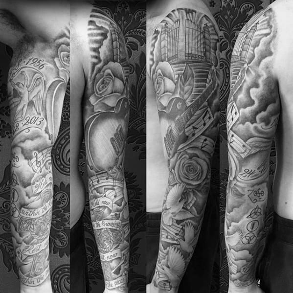 Black and gray full sleeve tattoo with Led Zeppelin symbols, guitar, musical notes, angel wings, roses, and memorial dates.