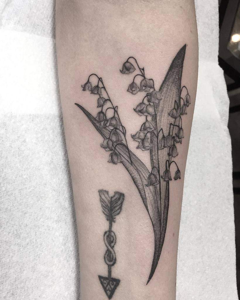 Elegant black and grey Lily of the Valley tattoo, featuring delicate bell-shaped flowers, arrow with infinity next to it