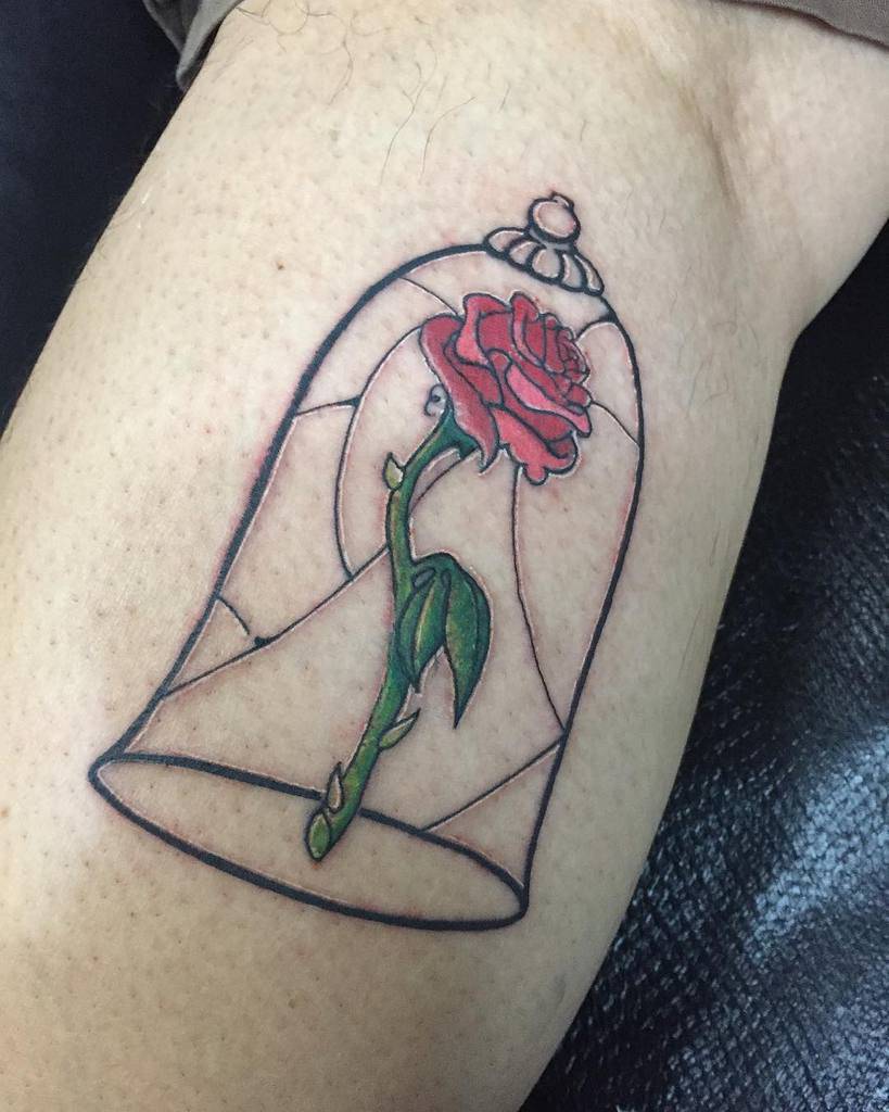 Tattoo of a red rose inside a glass dome on a leg