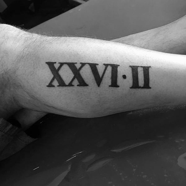 Bold Roman numeral tattoo reading “XXVI•II” for 26.2, a classic tribute to completing a full marathon.