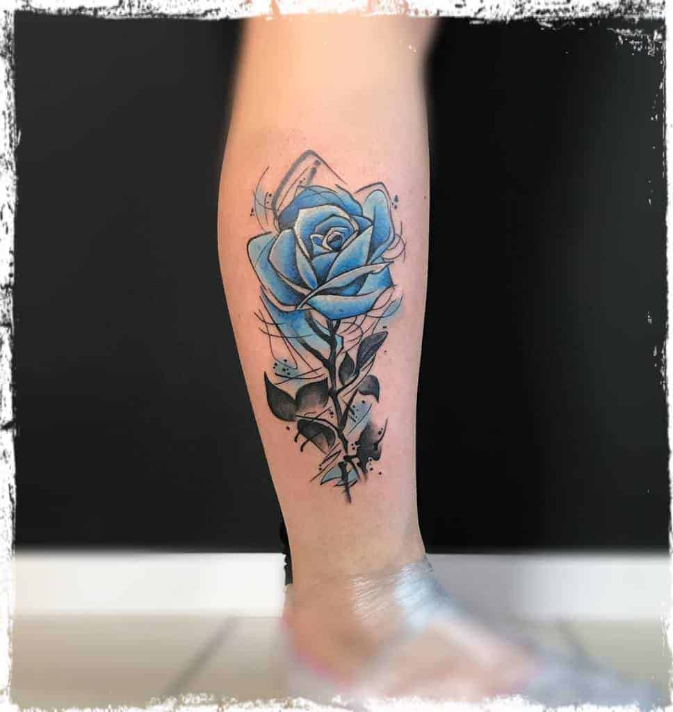 Tattoo of a blue rose with abstract geometric elements on a calf