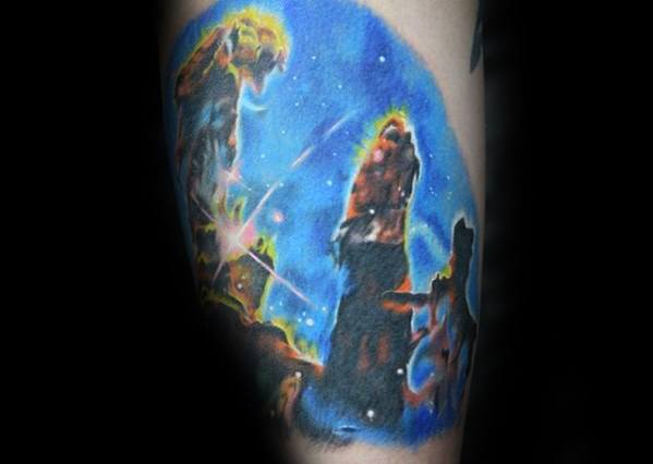 Nebula tattoo of cosmic pillars in vibrant blue and orange