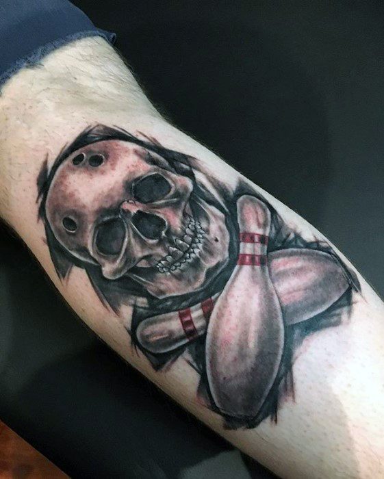 Tattoo of a grinning skull with bowling ball holes and two crossed bowling pins, blending dark art with a love for the sport.