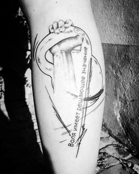 Sketch-style tattoo of a hand gripping a kettlebell with Russian text translating to "Will is decisive," symbolizing strength, determination, and resilience.