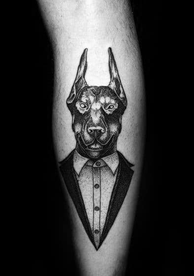 Dotwork Doberman tattoo in a suit, combining precision pointillism and clean lines for a sharp, stylish, and artistic look.