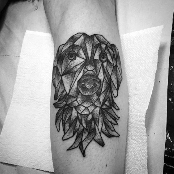 A striking geometric tattoo of a dog’s face, created with angular, faceted shapes and detailed shading, giving it a unique and artistic appearance.
