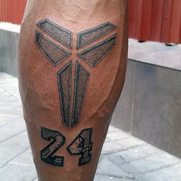 A tattoo of Kobe Bryant's iconic "Mamba" logo above his number 24, designed with bold, geometric lines and detailed shading.