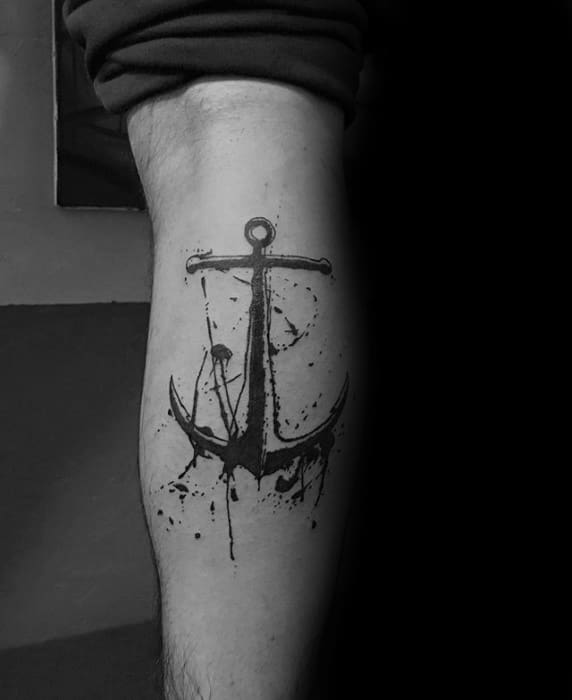 Black ink anchor tattoo with splatter design on a person's leg
