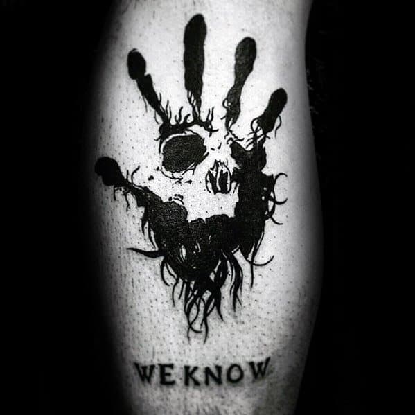 Tattoo featuring a Skyrim-inspired black handprint with skull design and "WE KNOW" text below