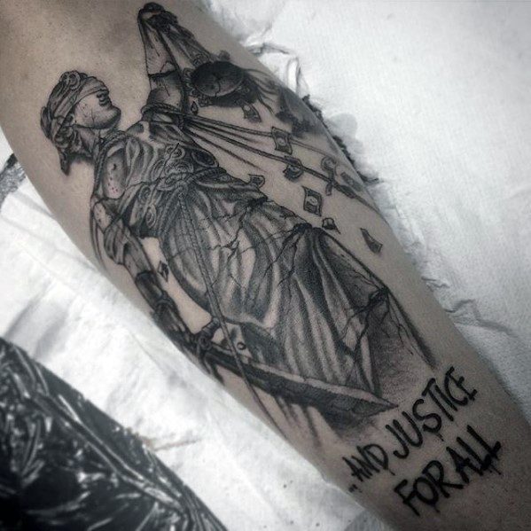 Detailed black and grey tattoo of Lady Justice with broken scales, chains, and the text ...And Justice For All, inspired by Metallica’s album art.