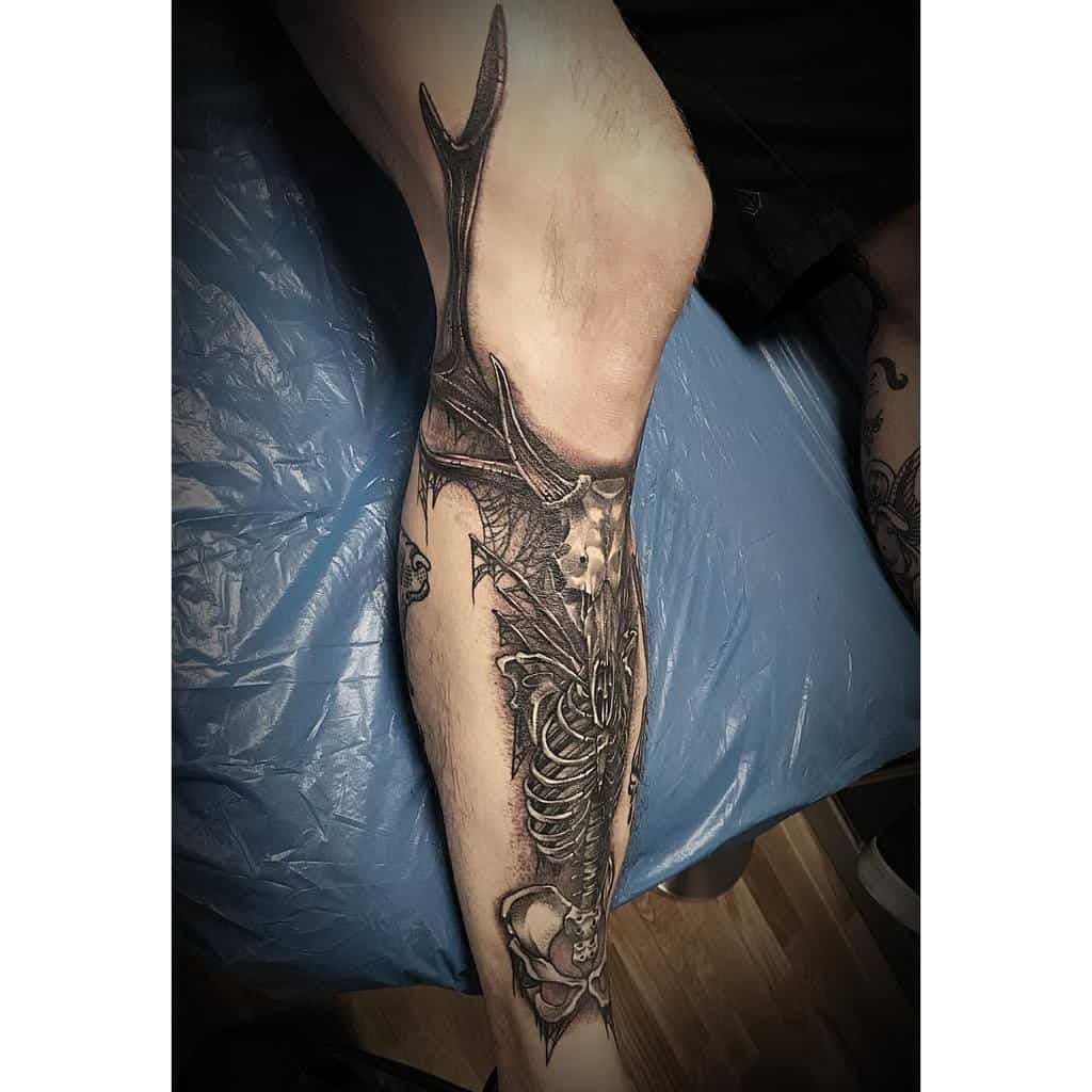 A leg tattoo featuring intricate antlers and a detailed deer skull with expert shading