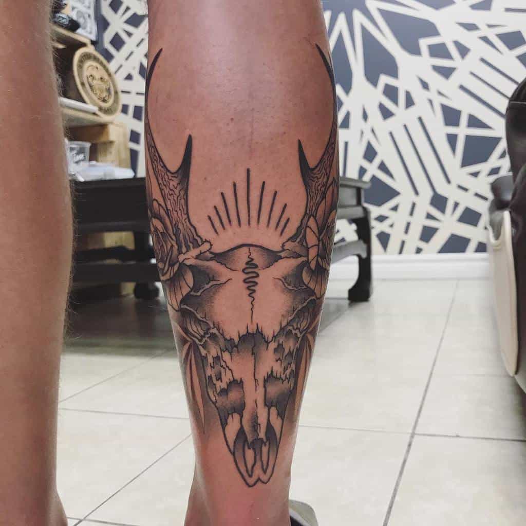 Calf tattoo featuring an intricate deer skull design with elaborate patterns