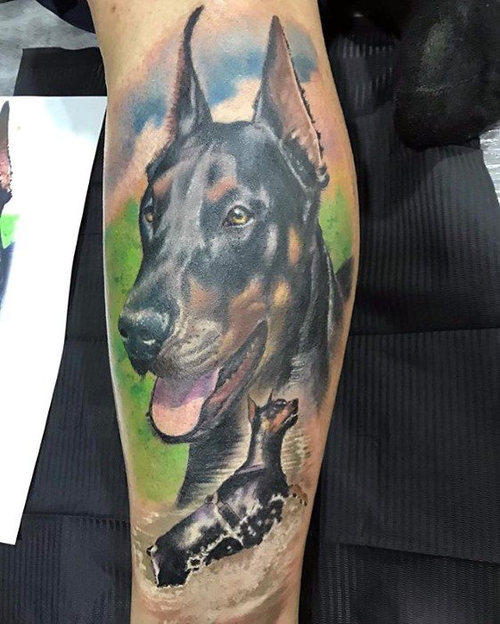 Vibrant Doberman tattoo with a large portrait and a smaller image of the dog running through water, set against a colorful background.