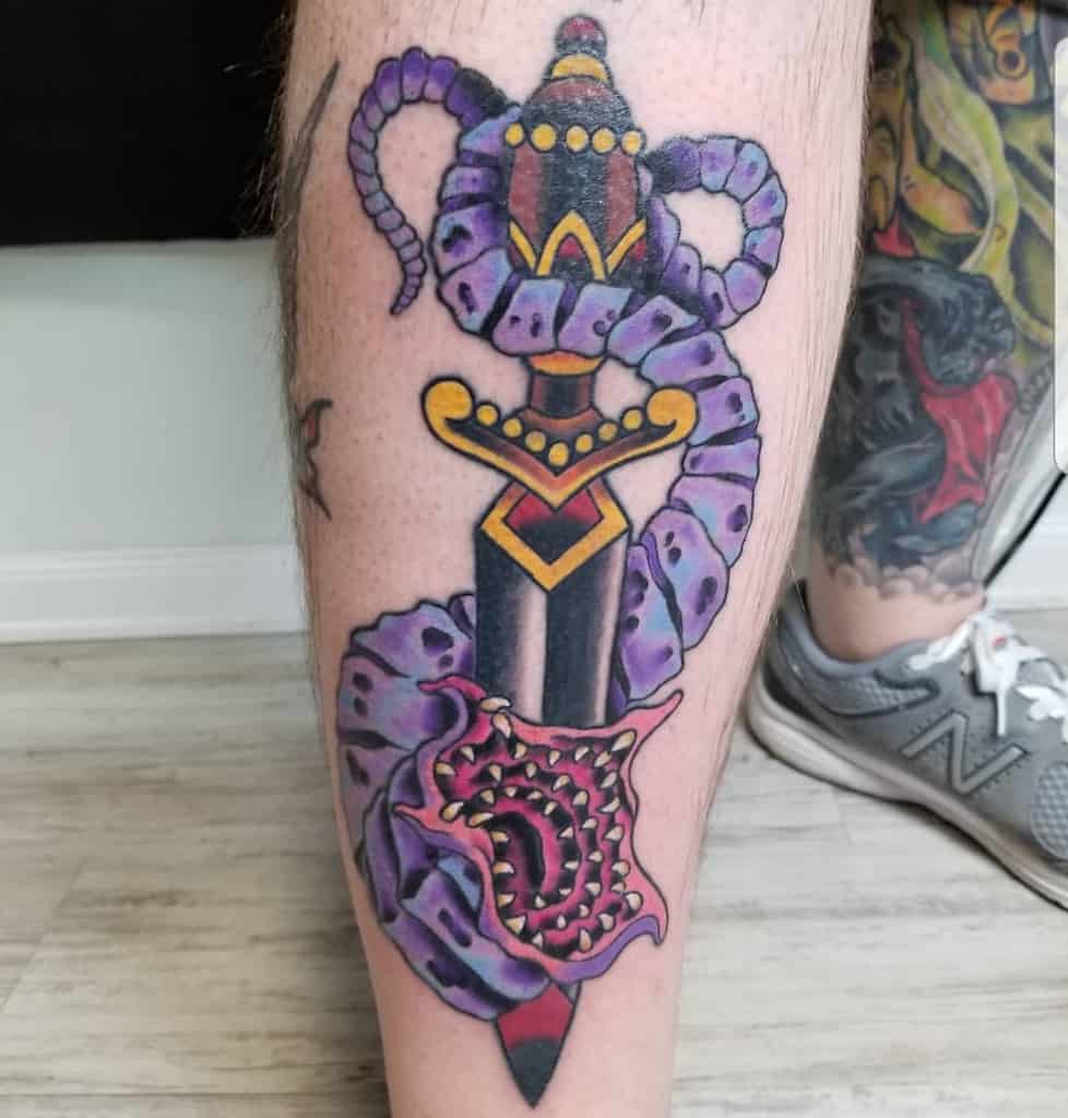 Leg tattoo of a vivid sword entwined with a tentacled creature, referencing D&D's mind flayers