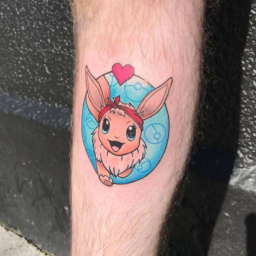 Adorable Eevee tattoo with a red headband and heart detail, set against a cheerful blue bubble background
