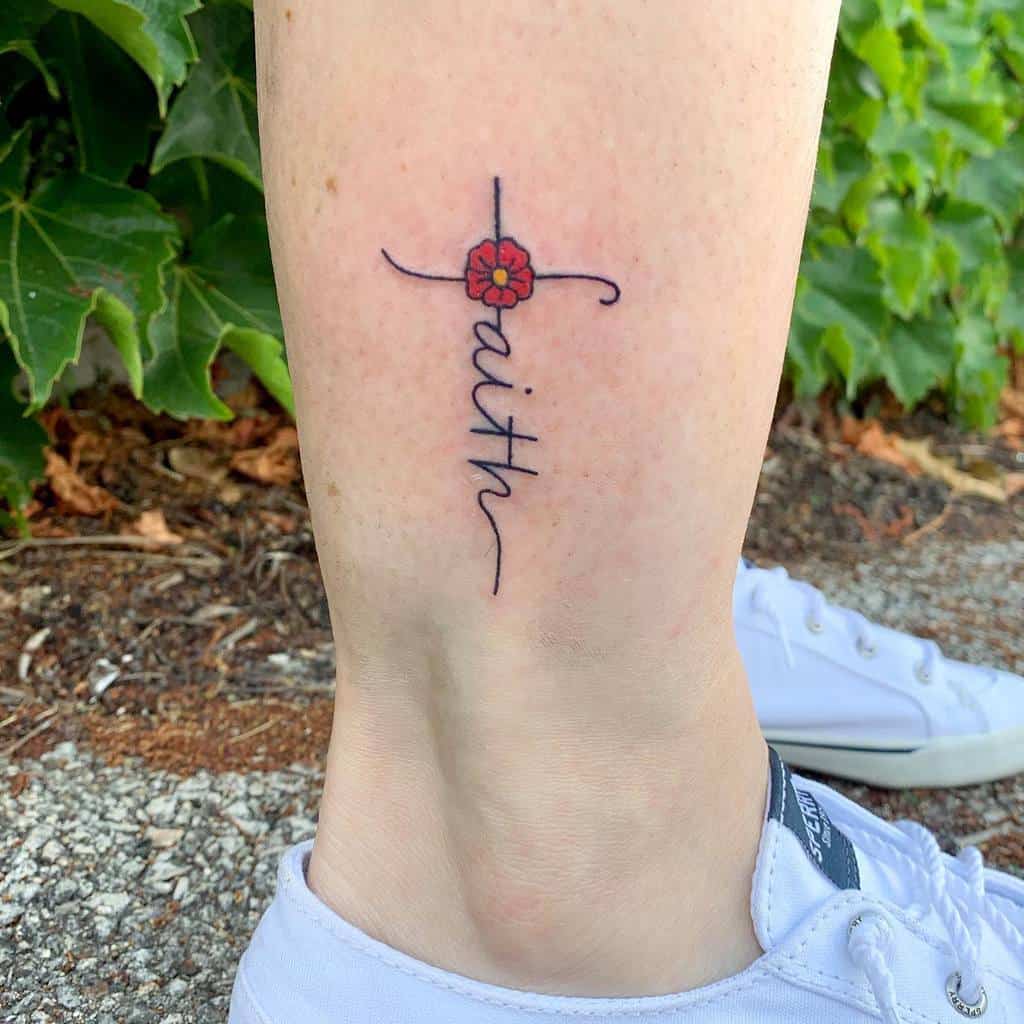 A tattoo of a cross adorned with a flower and the word "faith" elegantly graces the ankle