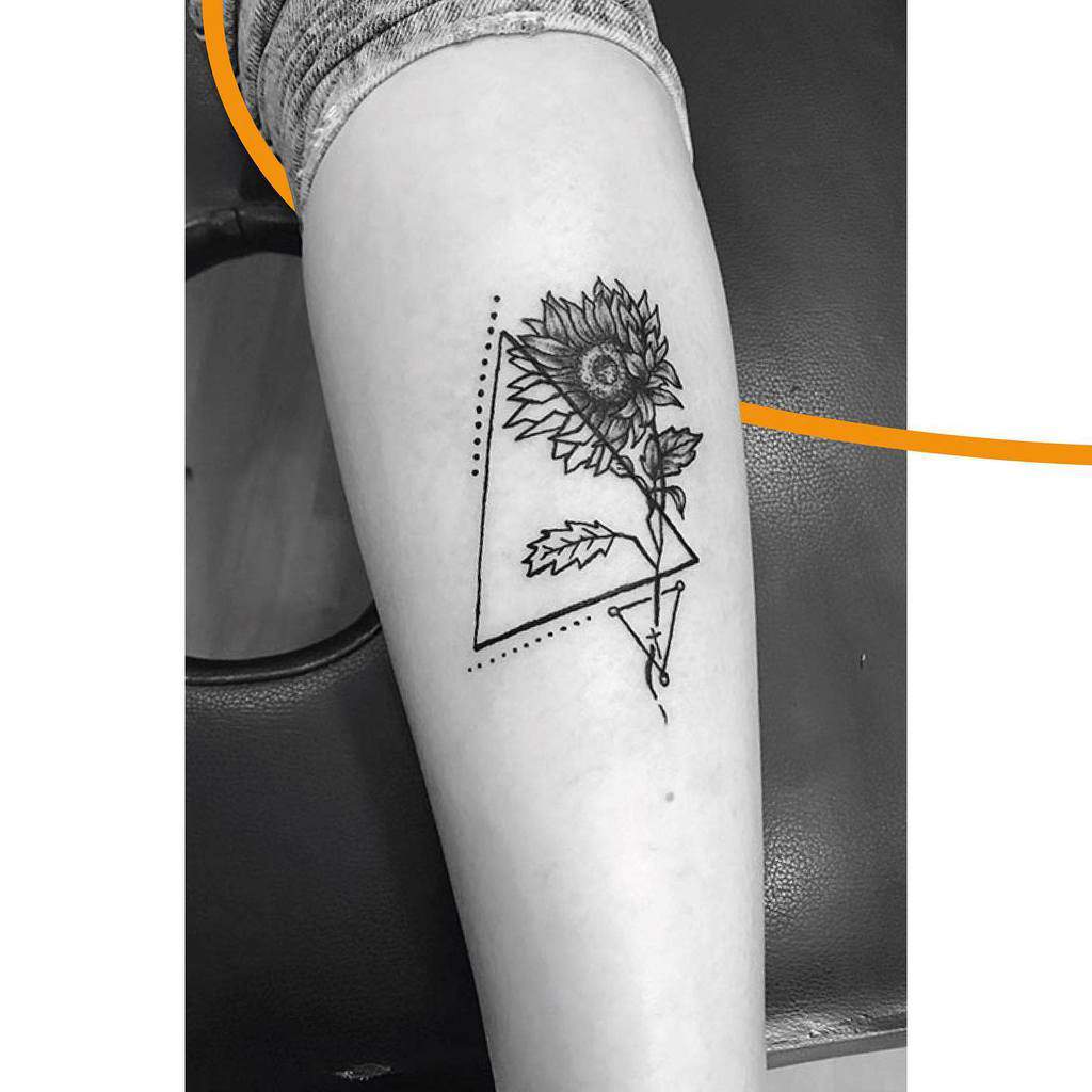 Black and white sunflower tattoo with geometric shapes on a calf