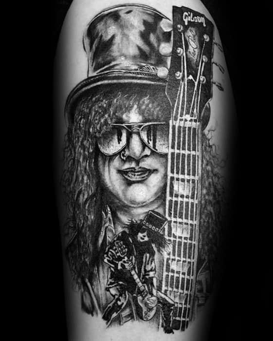 Detailed black and grey tattoo of Slash with his top hat, sunglasses, Gibson guitar, and a smaller figure of him playing live below.
