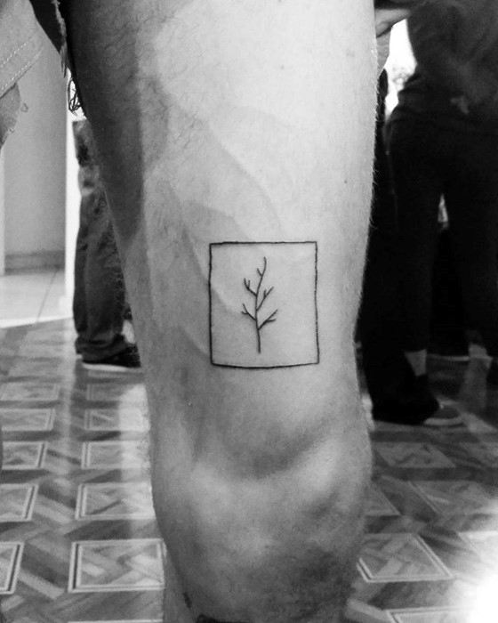 Minimalist tree branch tattoo inside a square frame on a leg