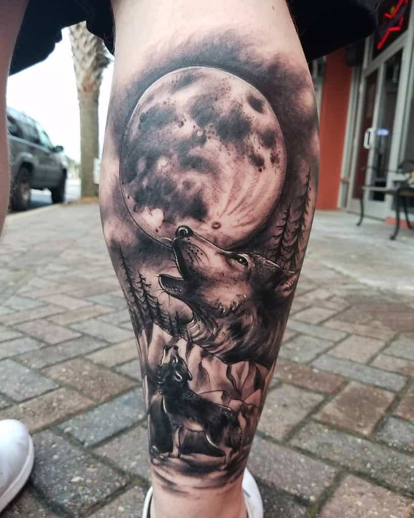 Tattoo of wolves howling at a full moon with trees in the background