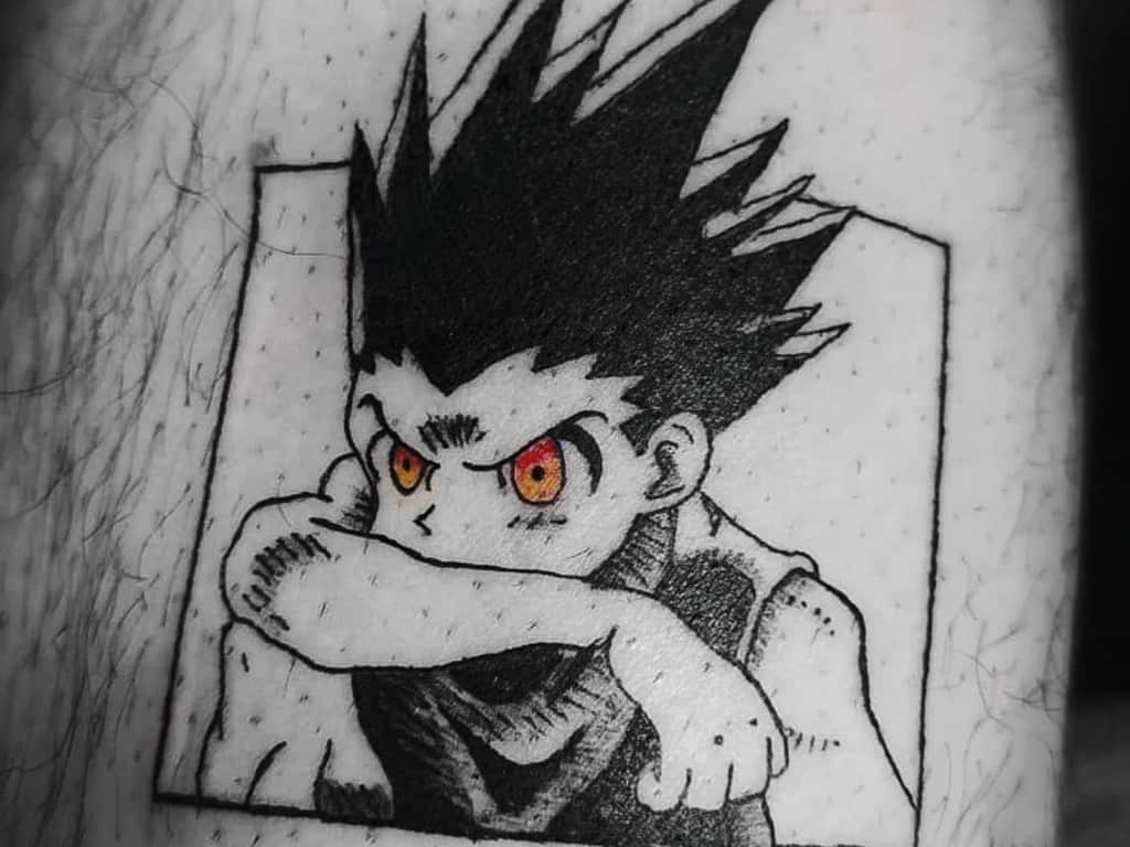 Black and white tattoo of Gon from Hunter X Hunter, showcasing an intense expression with orange eyes