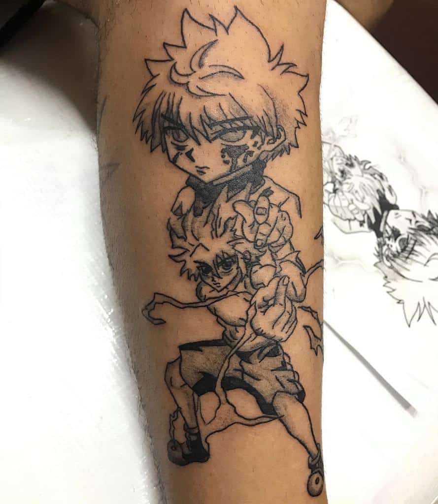 Black line tattoo of Killua from Hunter X Hunter, featuring a dynamic pose with a smaller image of him below, on a person's forearm