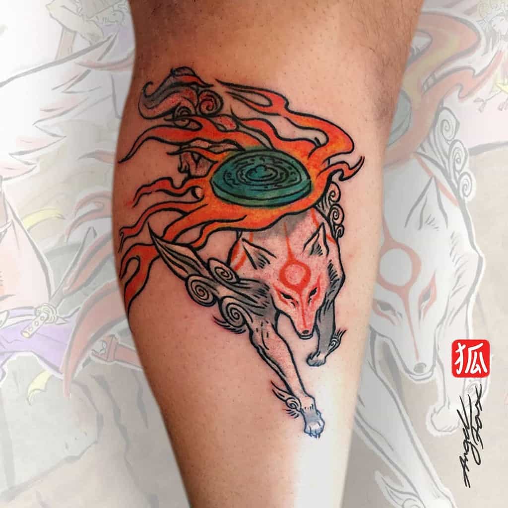 A colorful tattoo of a mythical wolf, inspired by Japanese folklore, with swirling orange and red flames and a green disc on its back