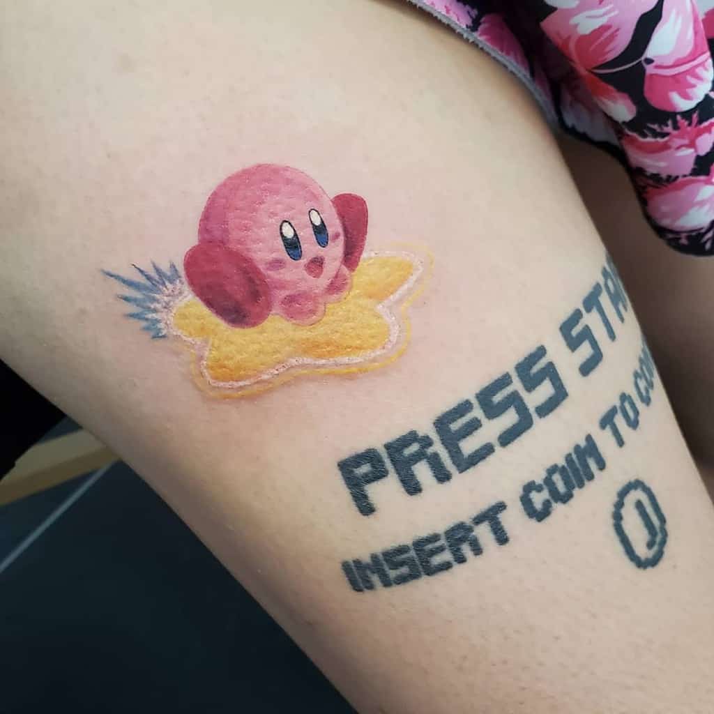 Kirby tattoo riding a Warp Star with a soft, pastel texture, next to an arcade-style "PRESS START INSERT COIN TO CONTINUE" text with coin