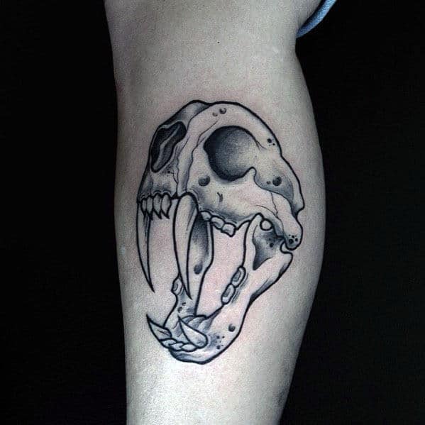 Tattoo of a saber-toothed tiger skull on a forearm