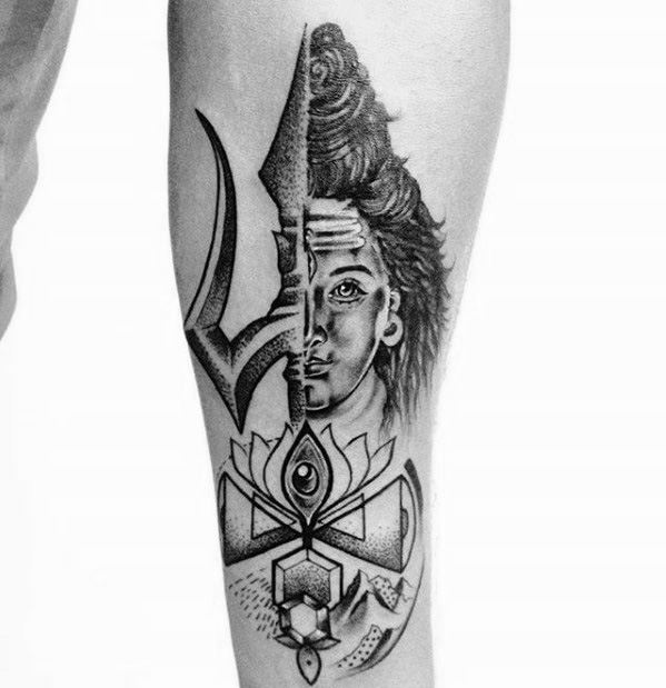 Forearm tattoo of Lord Shiva with a split-face design merging into a trishul, lotus, and sacred geometric elements, symbolizing divine balance and energy.