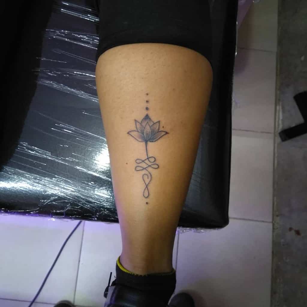 Unalome tattoo with a lotus on the calf, symbolizing spiritual enlightenment, growth, and the journey toward inner peace.