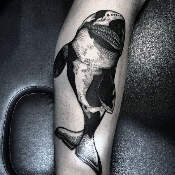 Detailed black and gray orca tattoo on the forearm, showcasing a striking contrast between dark shading and detailed linework to highlight the whale's unique features.