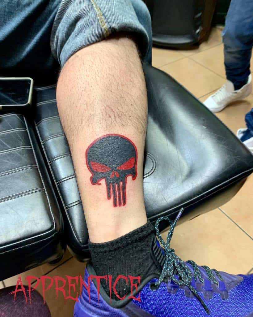 A leg tattoo of a Punisher Skull with red outline