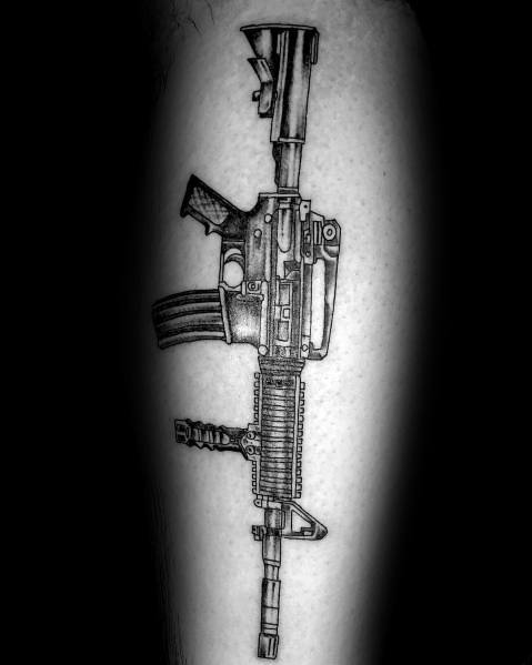 Black and grey AR-15 tattoo on the leg, featuring detailed shading and a tactical grip, symbolizing strength, precision, and firearm appreciation.