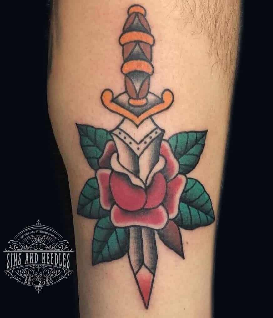 Tattoo of a dagger piercing a rose on a leg