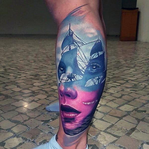 Surreal leg tattoo blending a woman's face with sailing ships and sky, using bold pink and blue tones for a dreamy, layered effect.