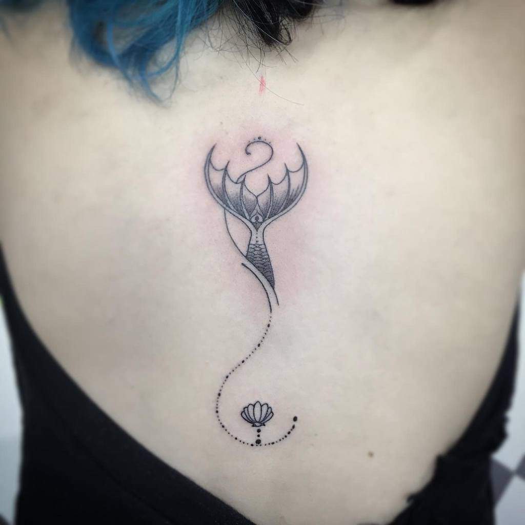 Abstract tattoo of a stylized siren's tail and flower on a back