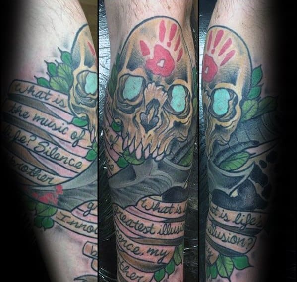 A Skyrim-inspired tattoo featuring a colorful skull with text ribbons wrapped around it on a leg