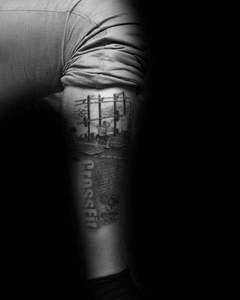 Detailed CrossFit-themed forearm tattoo featuring gym equipment, pull-up bars, and bold "CrossFit" text, symbolizing strength and dedication.