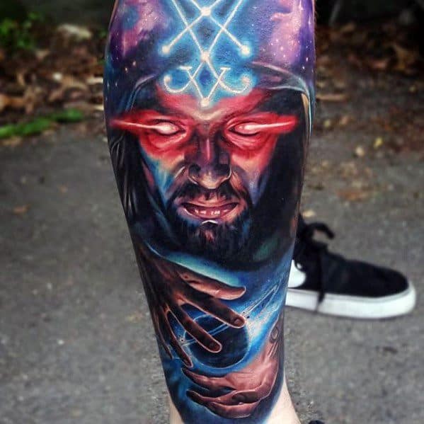 Colorful tattoo of a mystical magician with glowing red eyes and a glowing blue orb
